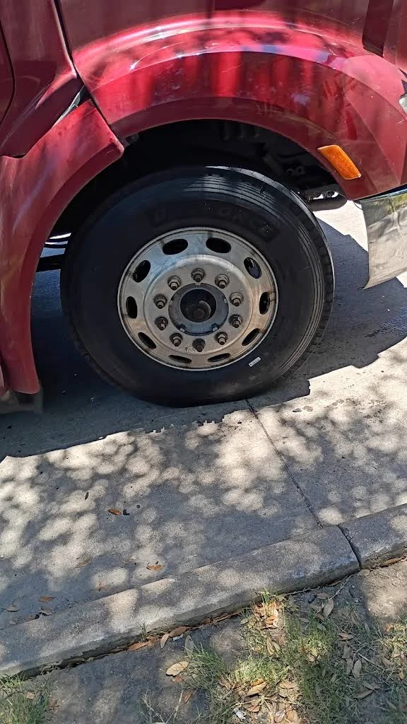 Red truck front tire in daylight