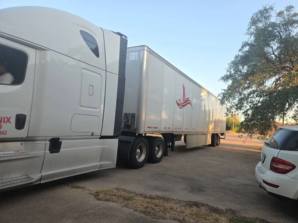 White semi truck and trailer parked beside the road