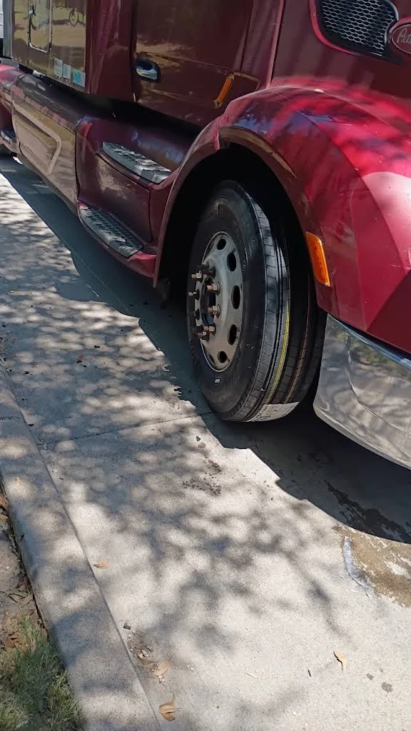 Red semi truck cab and front wheel
