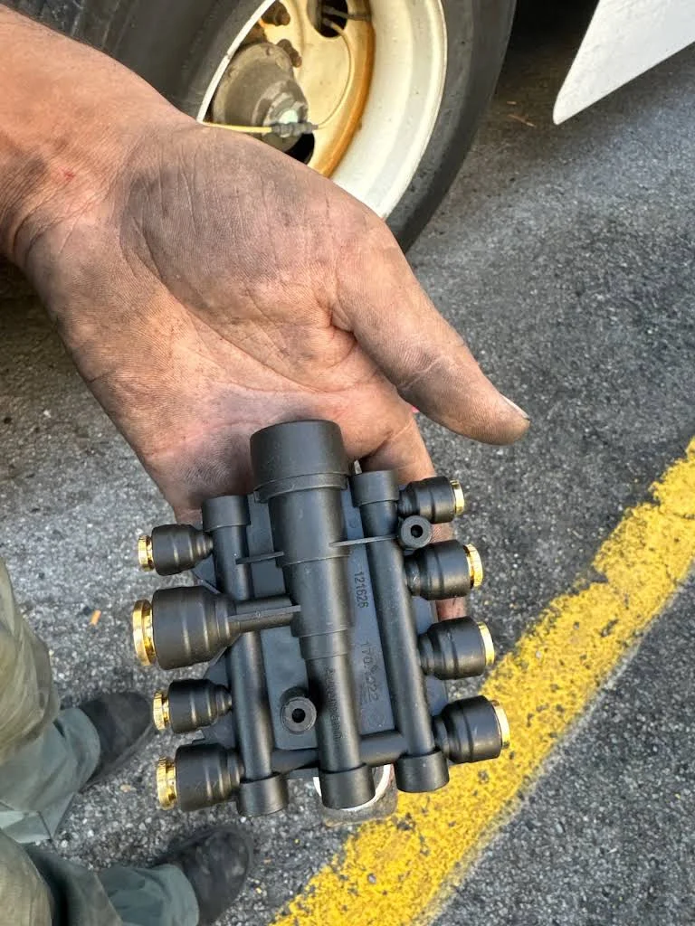 Truck repair component held beside a wheel