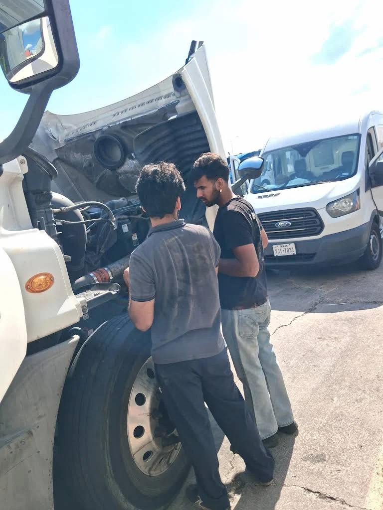 Technicians working beside an open truck hood