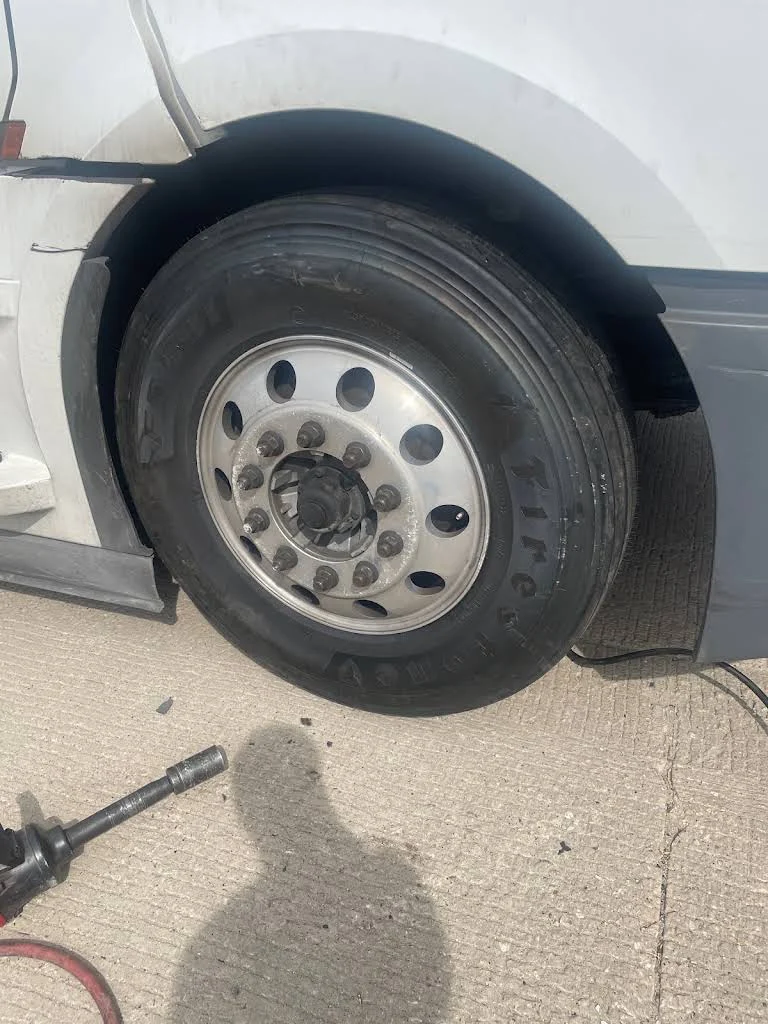 Truck tire with repair tools on the ground